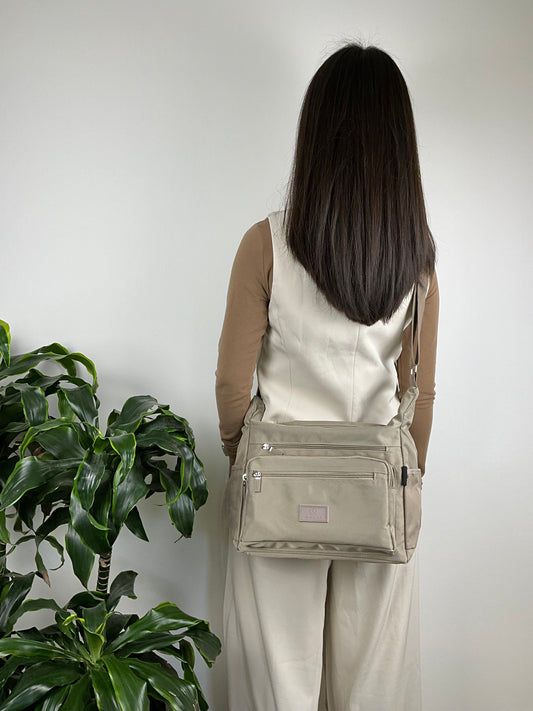 Model med MS Klassisk Skuldertaske i beige – bagsidevisning, elegant og tidløs design.