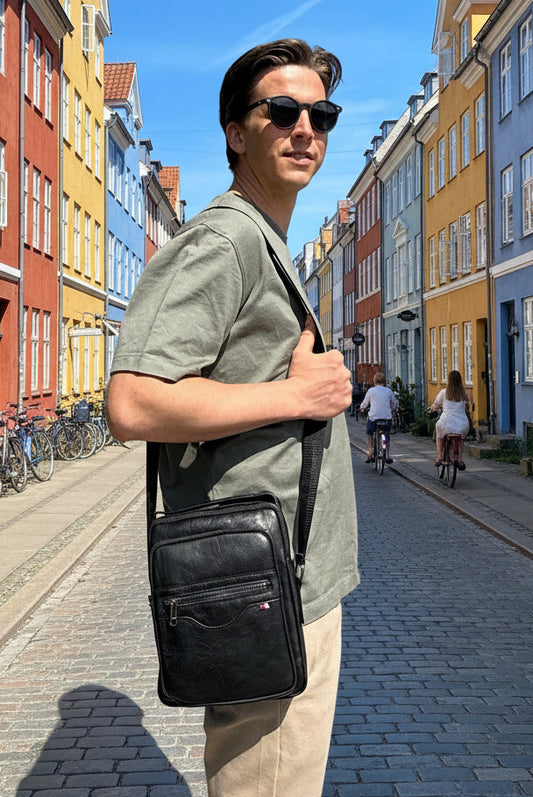 Mandlig model bærer Unisex Messenger Taske i sort over skulderen.