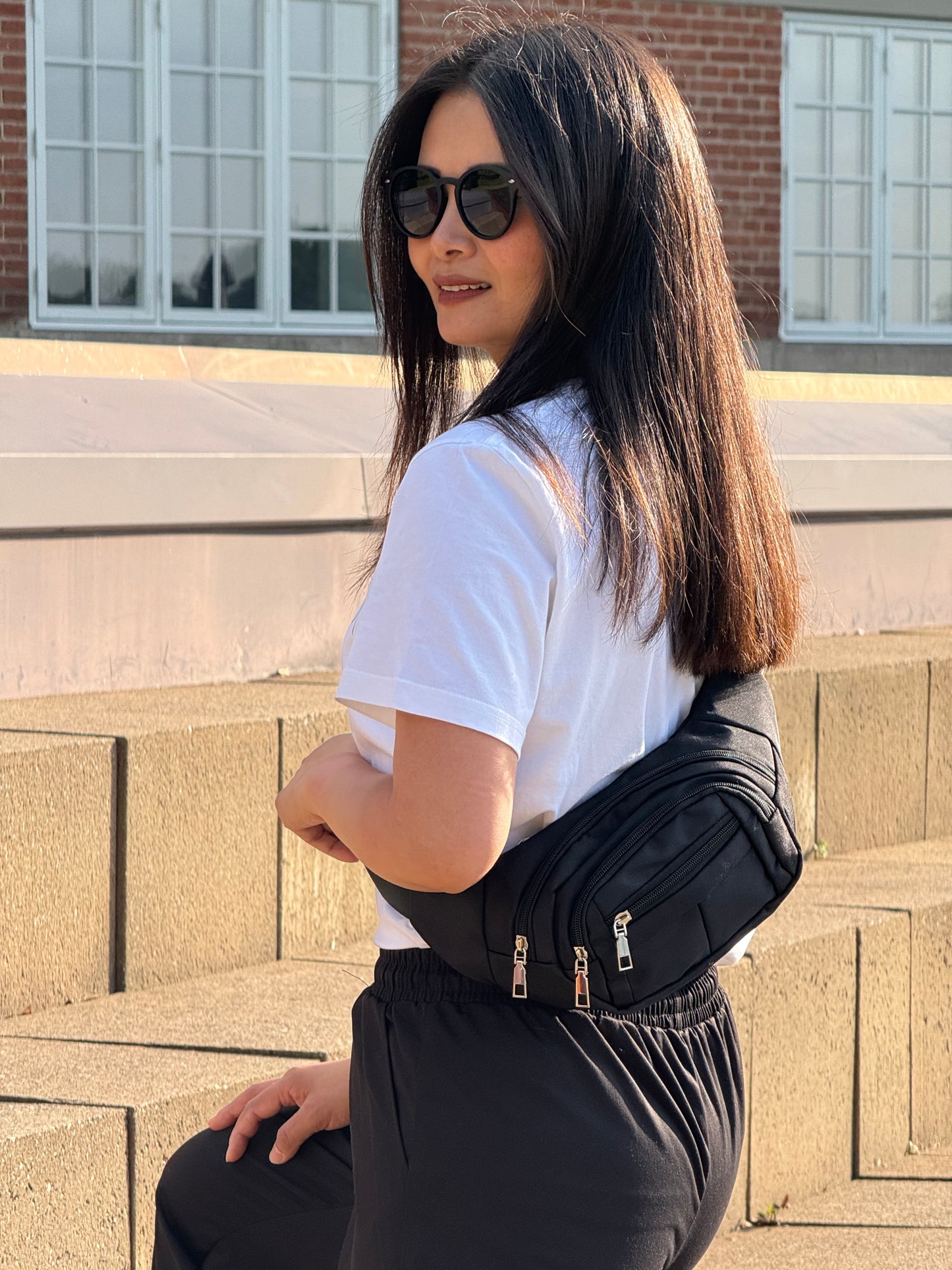 Kvindelig model med MS bæltetaske i sort båret på ryggen.