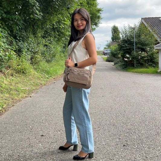 Kvindelig model bærer Katrine Skuldertaske Khaki over skulderen fra MAS SELECTION.